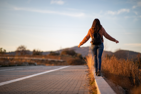 Eine junge Frau läuft auf einem Bordstein.