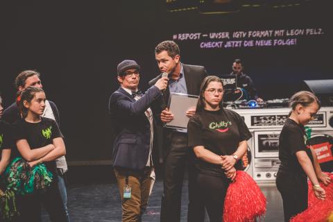 Moderator Siva und Teilnehmer des Trau-dich-Wettbewerbs auf der Bühne