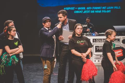 Moderator Siva und Teilnehmer des Trau-dich-Wettbewerbs auf der Bühne