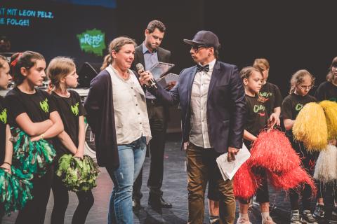 Moderator Siva und Teilnehmer des Trau-dich-Wettbewerbs auf der Bühne