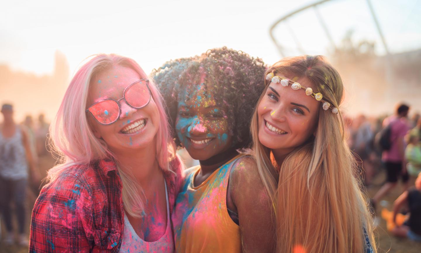 Drei junge Frauen voller Farbe auf dem Holy Festival of colors