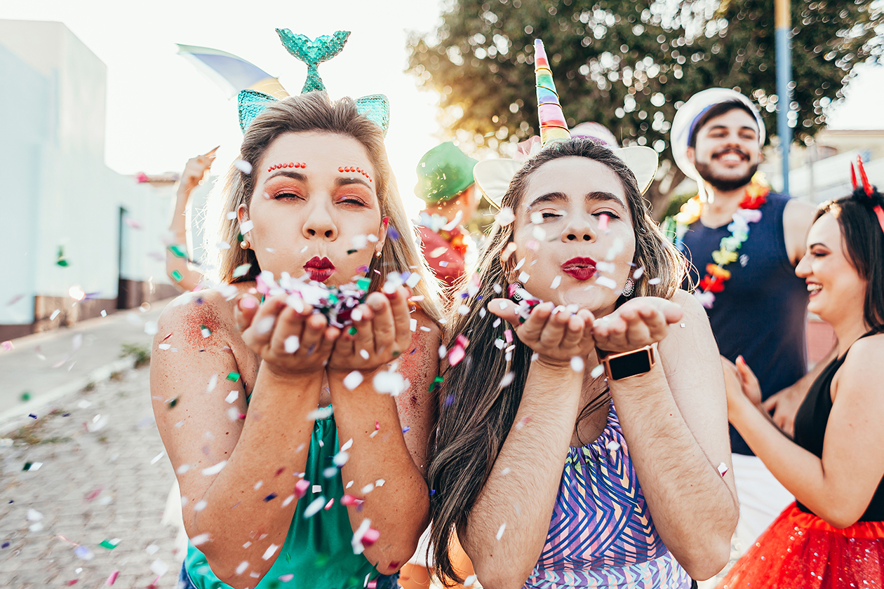 Zwei junge Frauen feiern, verkleidet als Meerjungfrau und Einhorn, Karneval.