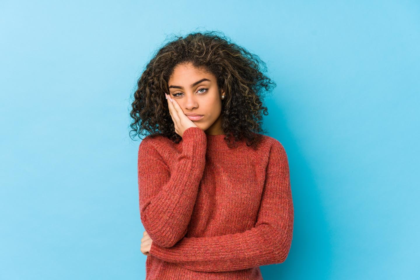 Young african american curly hair woman who is bored, fatigued and need a relax day.