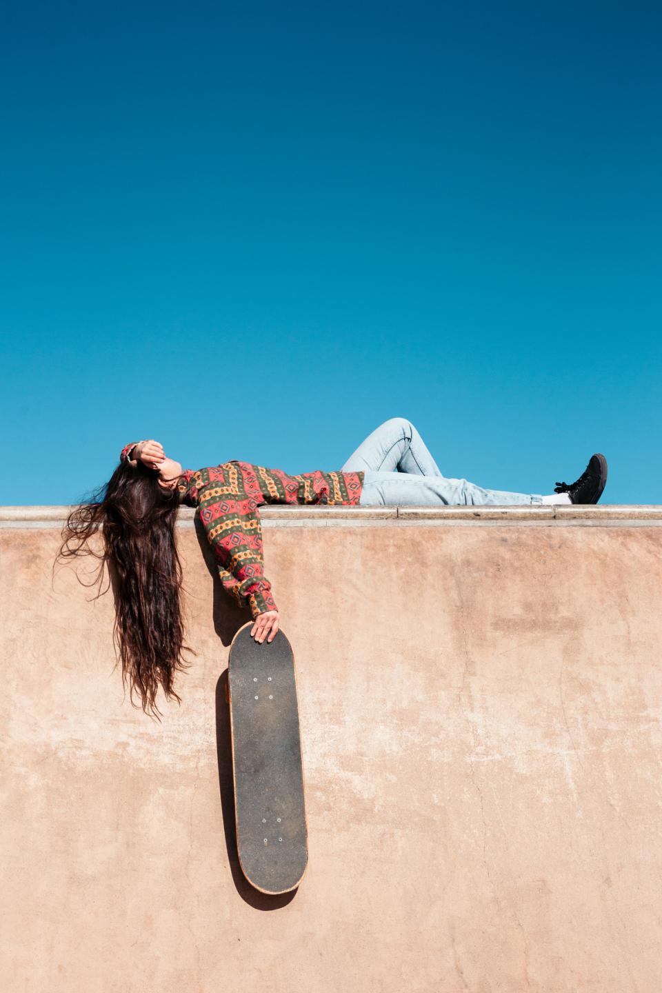 Skater Girl schläft auf Mauer