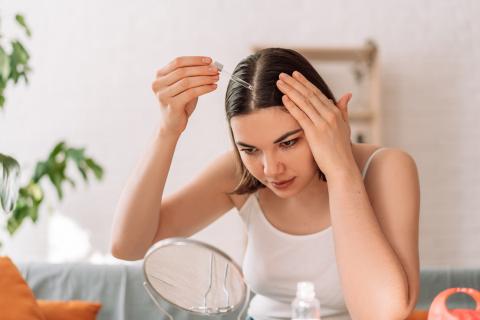 Junge Frau beim Hair Oiling mit Haaröl
