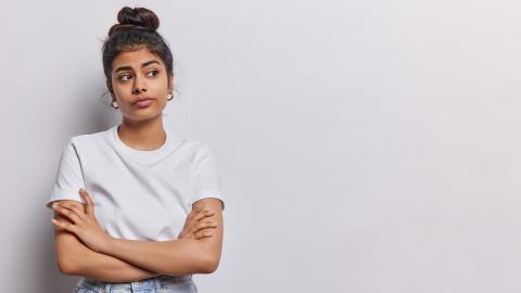 Junge Frau mit weißem T-Shirt und verschänkten Armen